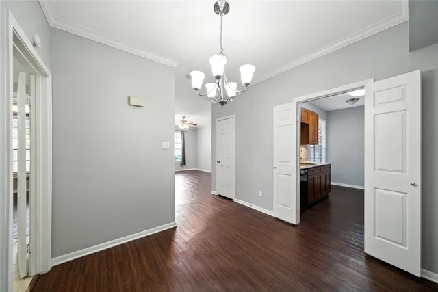 a view of a hallway with wooden floor and a chandelier
