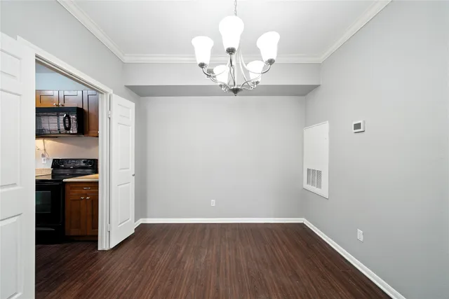 a view of a kitchen with wooden floor and stainless steel appliances