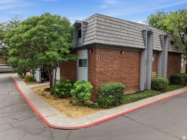 1700 Hickory Lane Provo, UT 84604 - Photo 7 of 20 Multi-unit building featuring brick and siding exterior, a textured roof, mature trees, and established landscaping