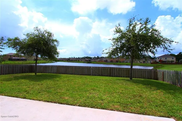 a view of a yard with a fence and trees