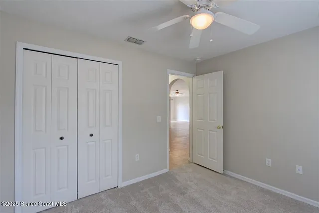 an empty room with chandelier fan