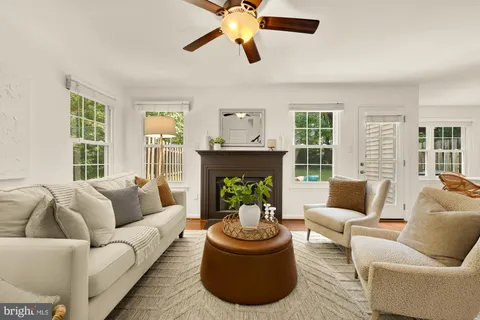 a living room with furniture a fireplace and a large window