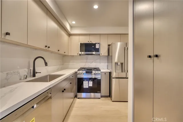 a kitchen with stainless steel appliances granite countertop a refrigerator and a stove top oven