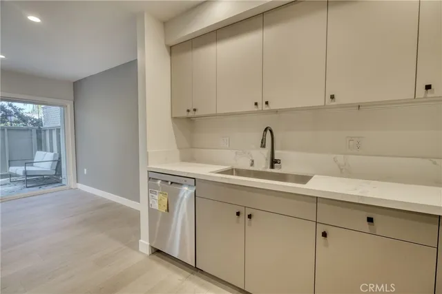 a kitchen with white cabinets sink and dishwasher