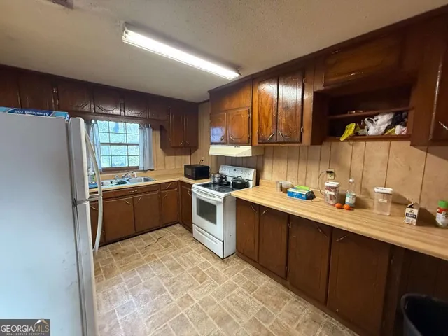 a kitchen with a sink stove and refrigerator