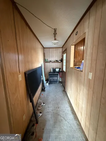 a view of a hallway with wooden floor and furniture