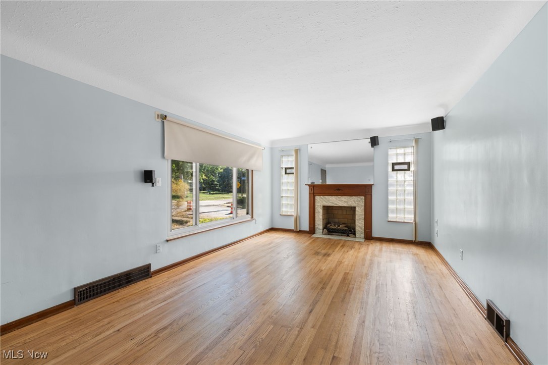 18122 Nottingham Road Cleveland, OH 44119 - Photo 2 of 29 Unfurnished living room featuring light wood-type flooring and a fireplace