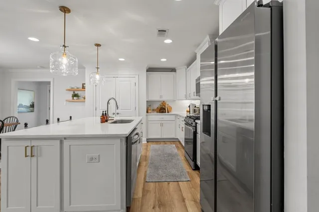 a kitchen with a sink refrigerator and cabinets