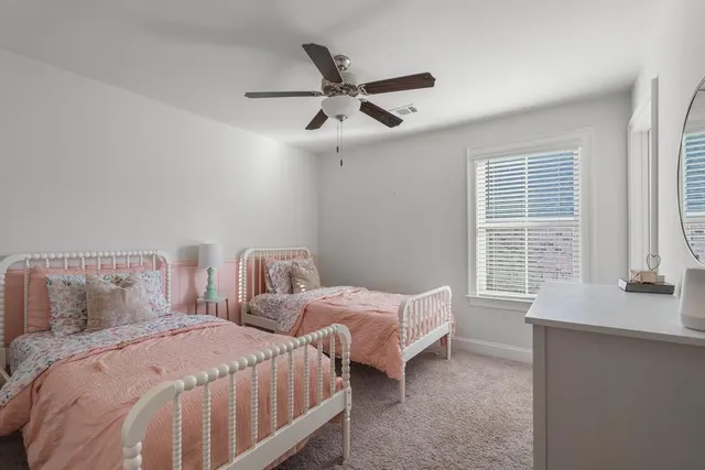a bedroom with two beds and a large window