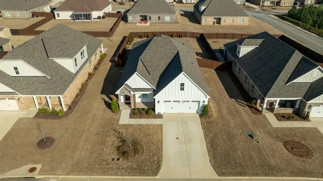 an aerial view of a house with a garden and lake view