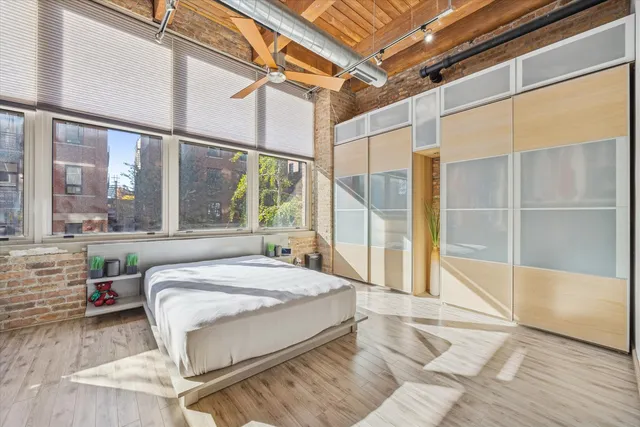 a bedroom with a large bed and a large window with the outer view