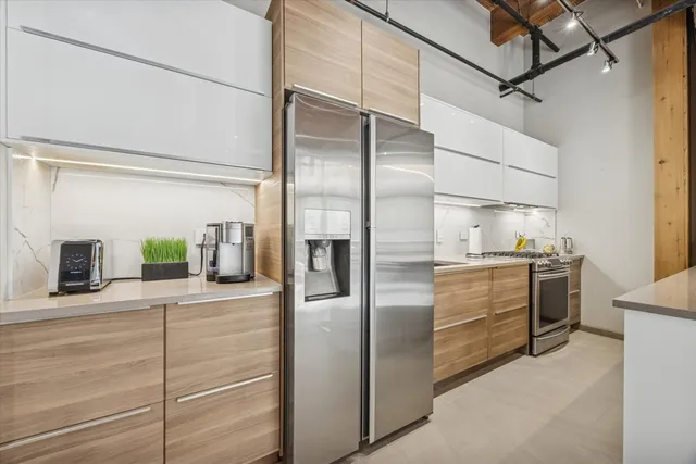 a kitchen with stainless steel appliances kitchen island granite countertop a refrigerator and a stove