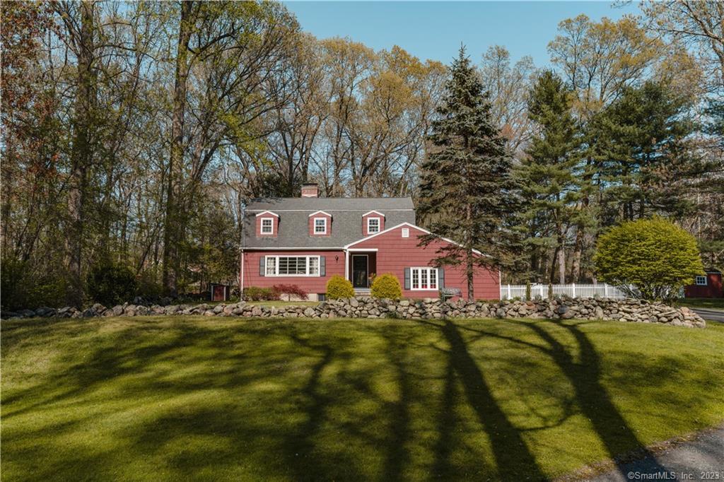 a view of a big house with a big yard and large trees