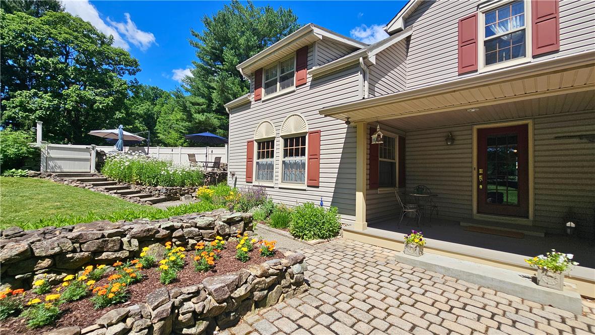 585 Buttermilk Road Hellertown, PA 18055 - Photo 39 of 82 A charming home boasts inviting red shutters, a cobblestone pathway, and a tiered garden leading to a private patio oasis.