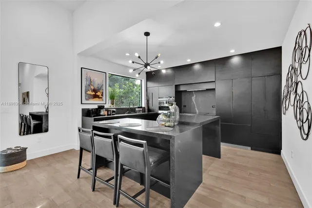 a kitchen with stainless steel appliances a table and chairs in it