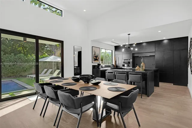 a dining room with furniture a floor to ceiling window and wooden floor