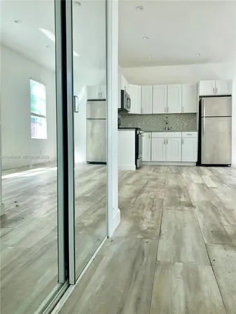 a view of a kitchen with a sink and a refrigerator