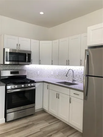 a kitchen with appliances a sink and cabinets