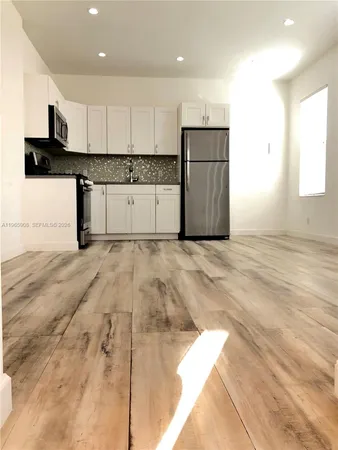 a kitchen with granite countertop white cabinets and stainless steel appliances