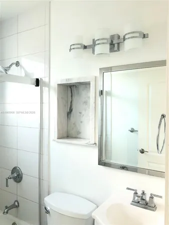 a bathroom with a sink and mirror with toilet