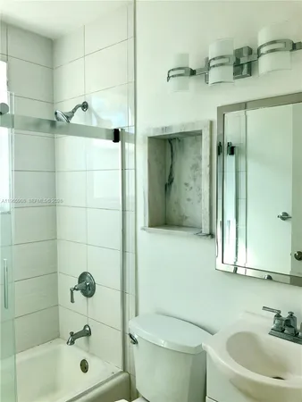 a bathroom with a bathtub shower sink vanity and toilet