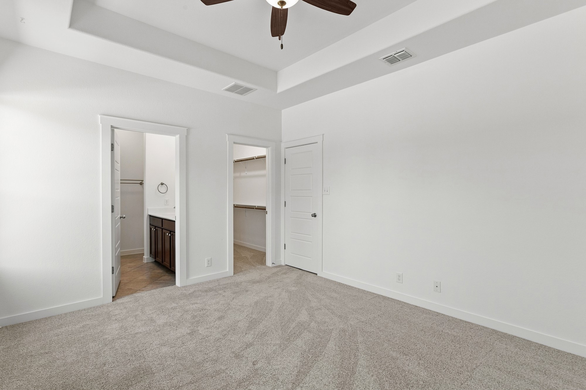 2101 Rivers Edge Way, Unit 25 Austin, TX 78741 - Photo 8 of 20 Recessed ceiling details and plush carpeting anchor this main bedroom suite.