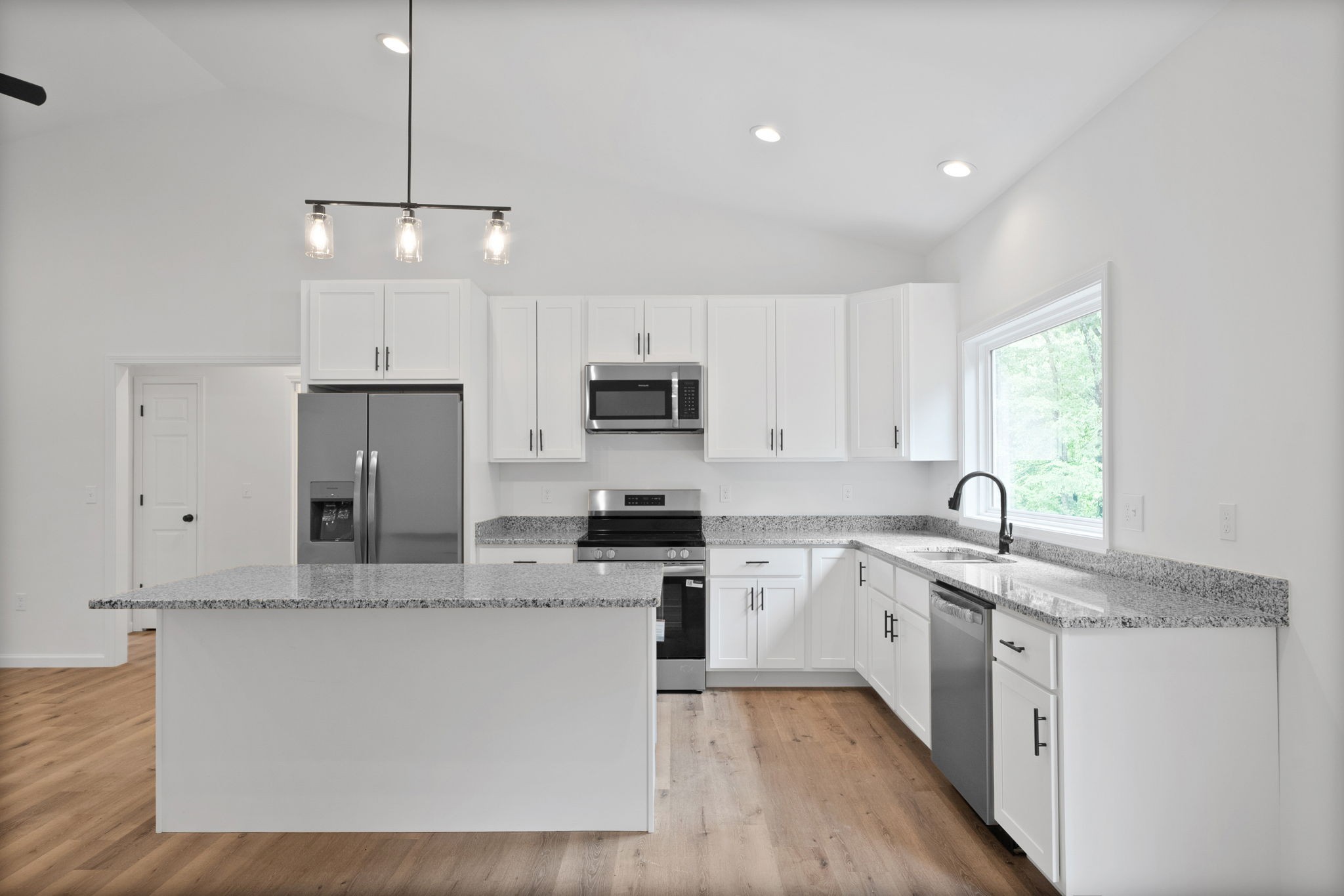 690 Brazzle Road Waverly, TN 37185 - Photo 13 of 35 a large kitchen with stainless steel appliances granite countertop a stove a sink dishwasher a refrigerator white cabinets and wooden floor