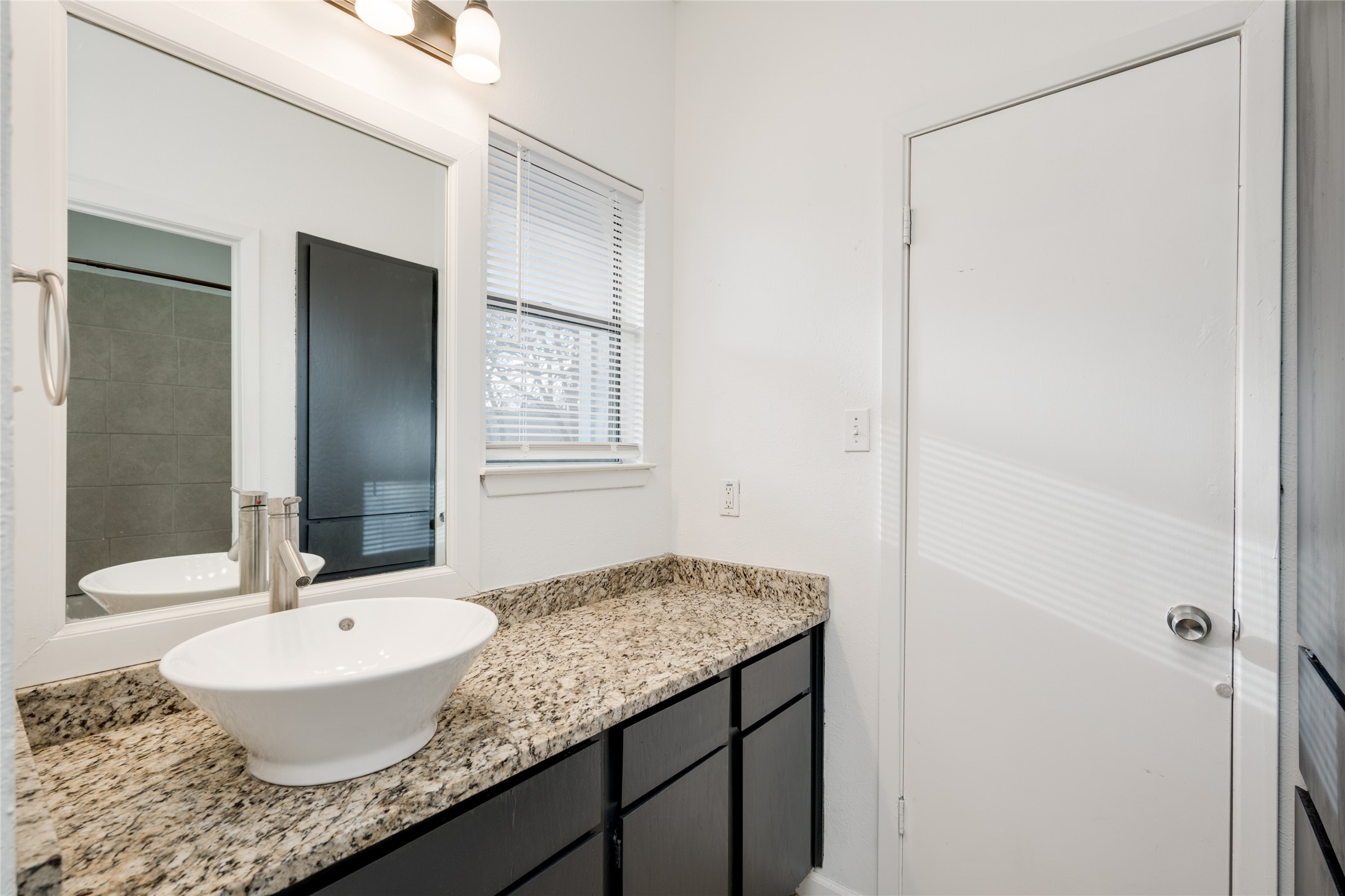 5304 Indio Cove, Unit B Austin, TX 78745 - Photo 18 of 40 a bathroom with a granite countertop sink and a mirror
