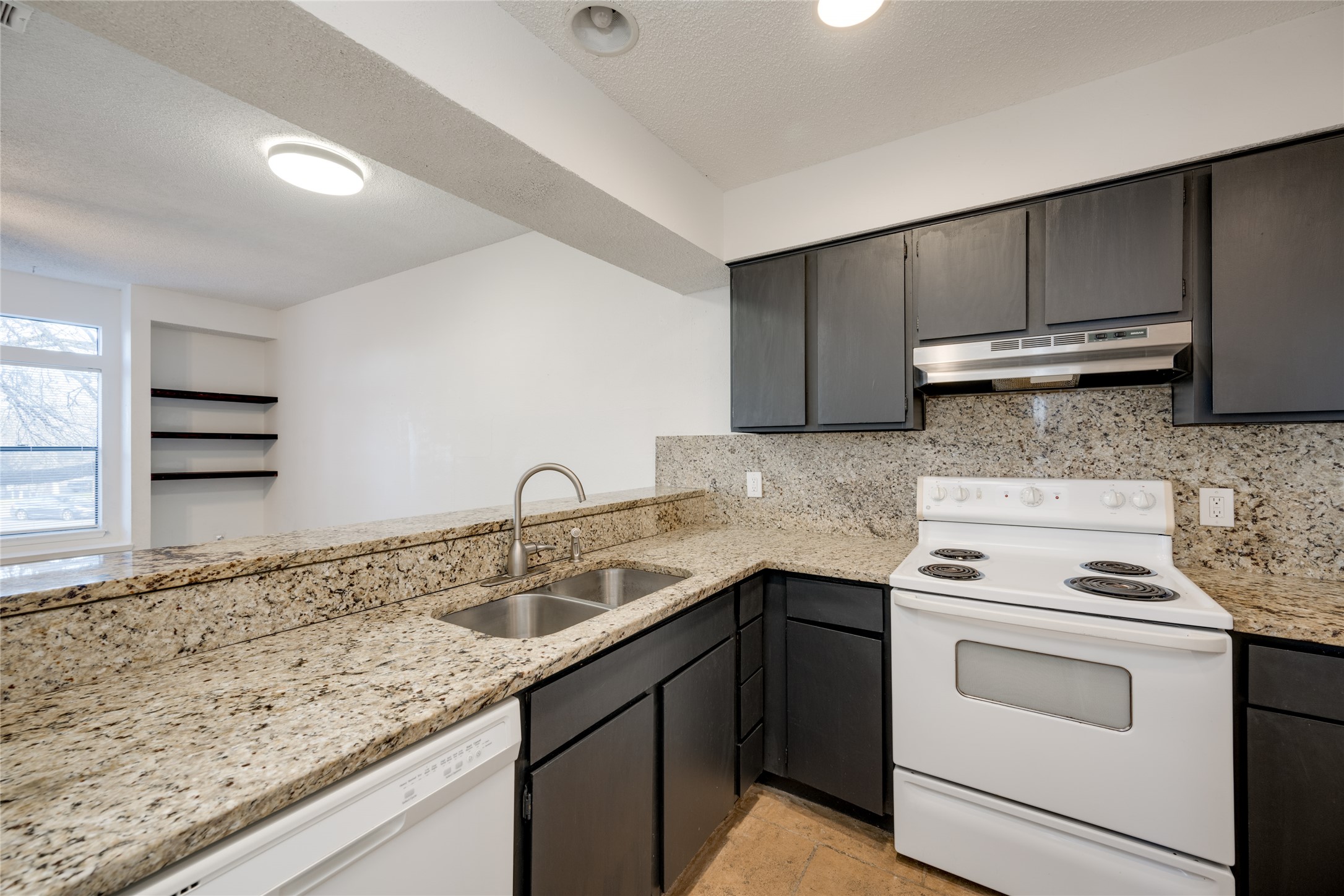 5304 Indio Cove, Unit B Austin, TX 78745 - Photo 9 of 40 a kitchen with granite countertop cabinets sink and stainless steel appliances