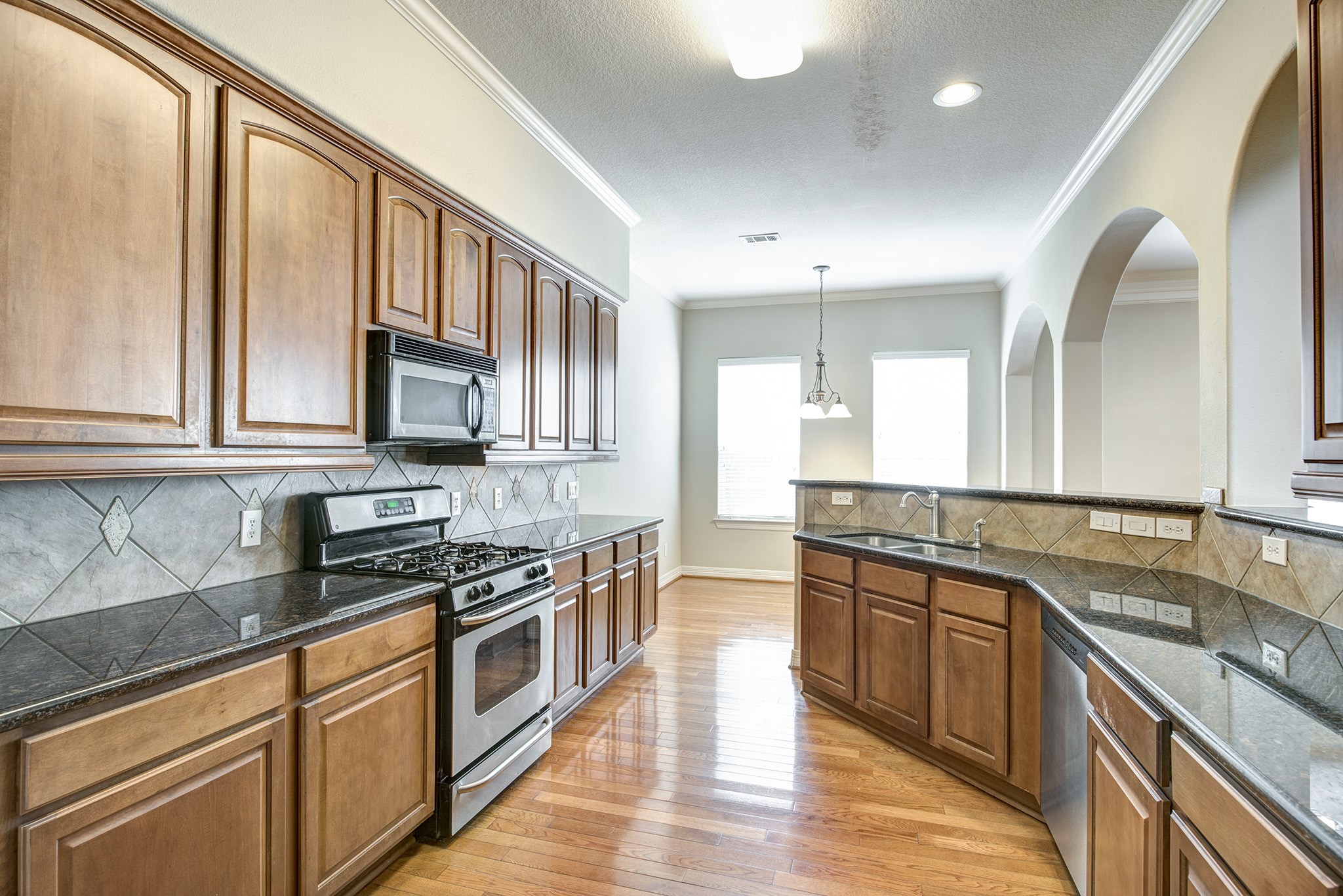 4003 Feagan Street, Unit 2 Houston, TX 77007 - Photo 9 of 25 a kitchen with stainless steel appliances granite countertop a stove a sink and a microwave