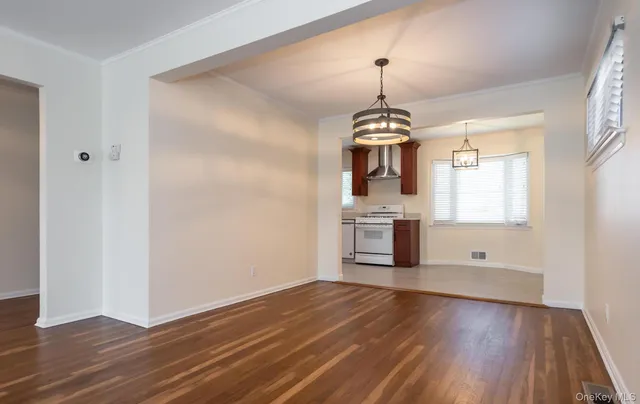 a kitchen with stainless steel appliances granite countertop a refrigerator a sink dishwasher a stove and a refrigerator with wooden floor