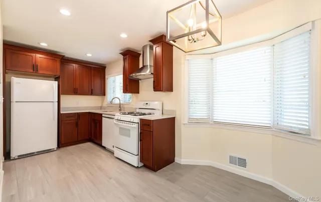 a kitchen with a sink cabinets stainless steel appliances and a window
