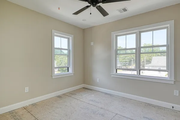 an empty room with a window and a fan