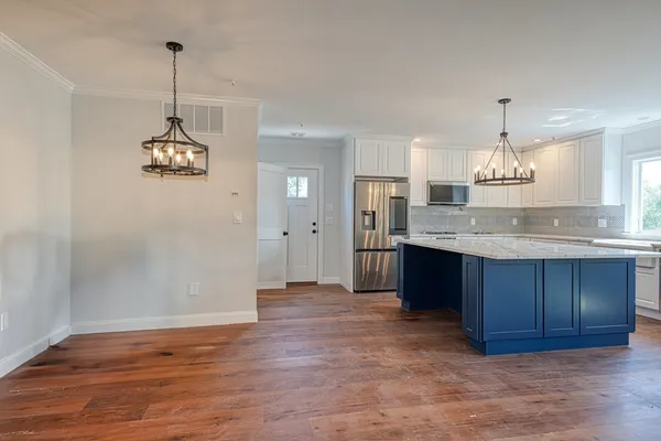 a kitchen with kitchen island granite countertop a sink cabinets and window