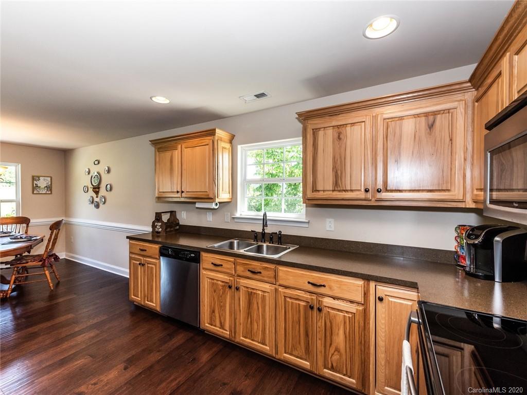 2910 Ruben Road Monroe, NC 28112 - Photo 13 of 29 a kitchen with stainless steel appliances granite countertop a sink a stove cabinets and wooden floor