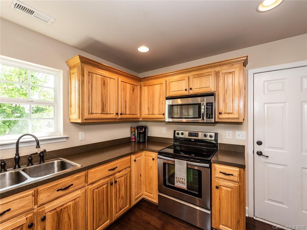 2910 Ruben Road Monroe, NC 28112 - Photo 14 of 29 a kitchen with stainless steel appliances a sink a stove a microwave and cabinets