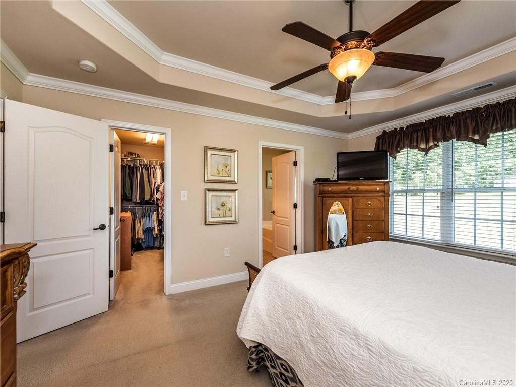 2910 Ruben Road Monroe, NC 28112 - Photo 16 of 29 a bedroom with a large bed and a chandelier