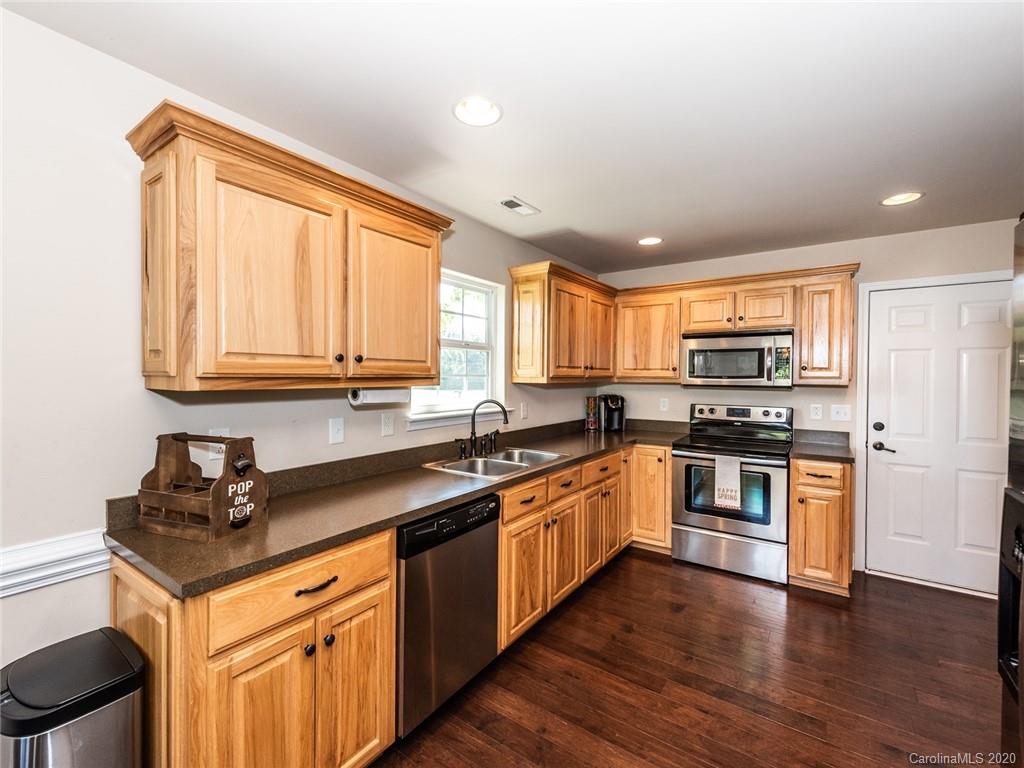 2910 Ruben Road Monroe, NC 28112 - Photo 10 of 29 a kitchen with stainless steel appliances granite countertop a sink a stove cabinets and wooden floor