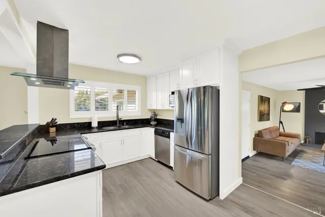 a kitchen with granite countertop a refrigerator and a sink