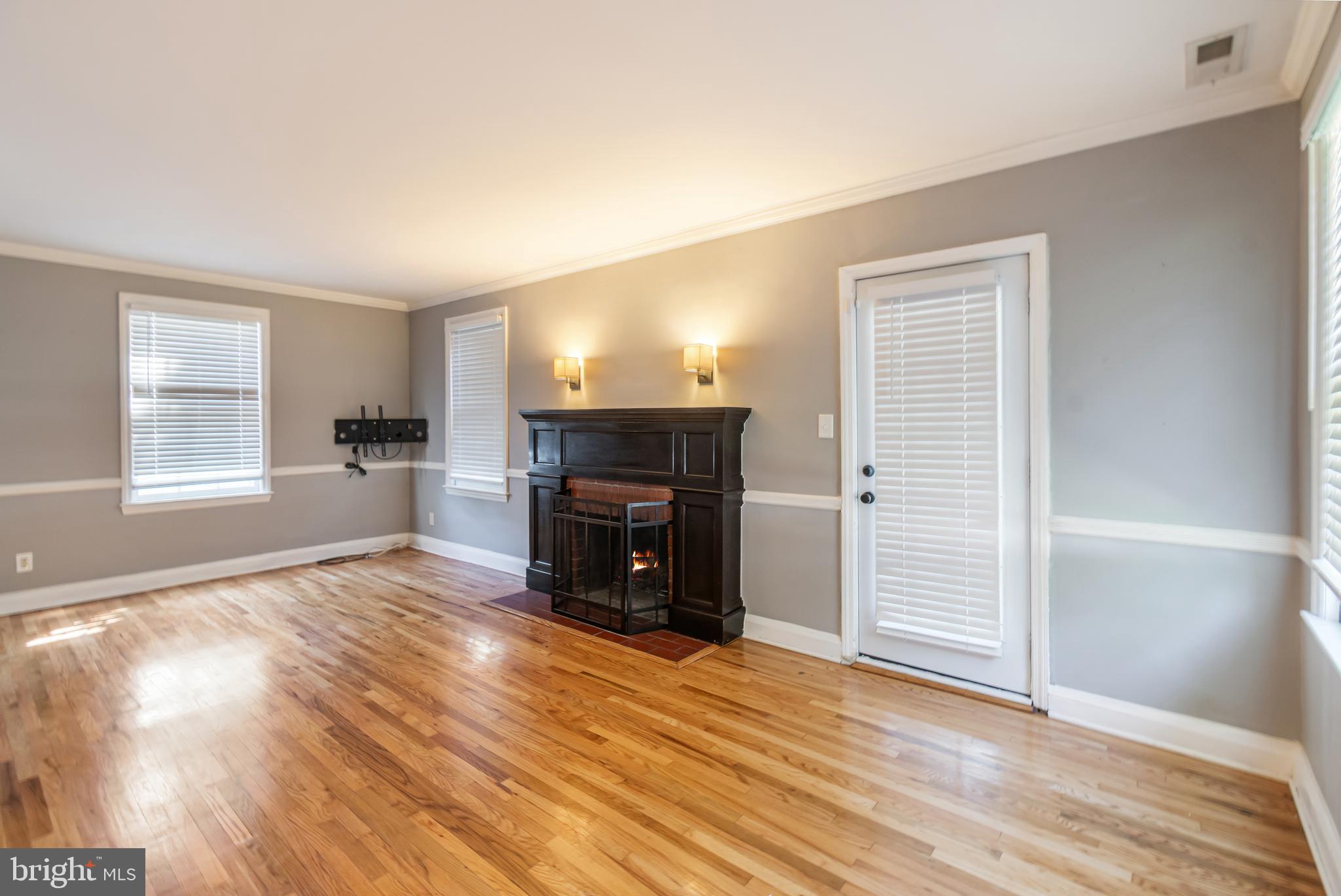 113 Homewood Road Linthicum Heights, MD 21090 - Photo 13 of 34 an empty room with wooden floor fireplace and windows