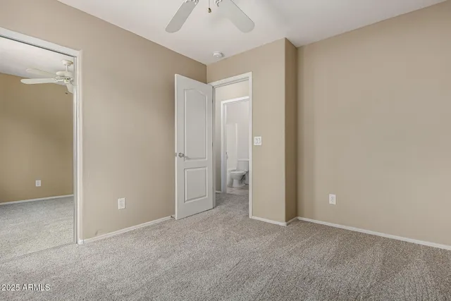 an empty room with closet and a chandelier fan