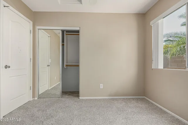 an empty room with windows and closet