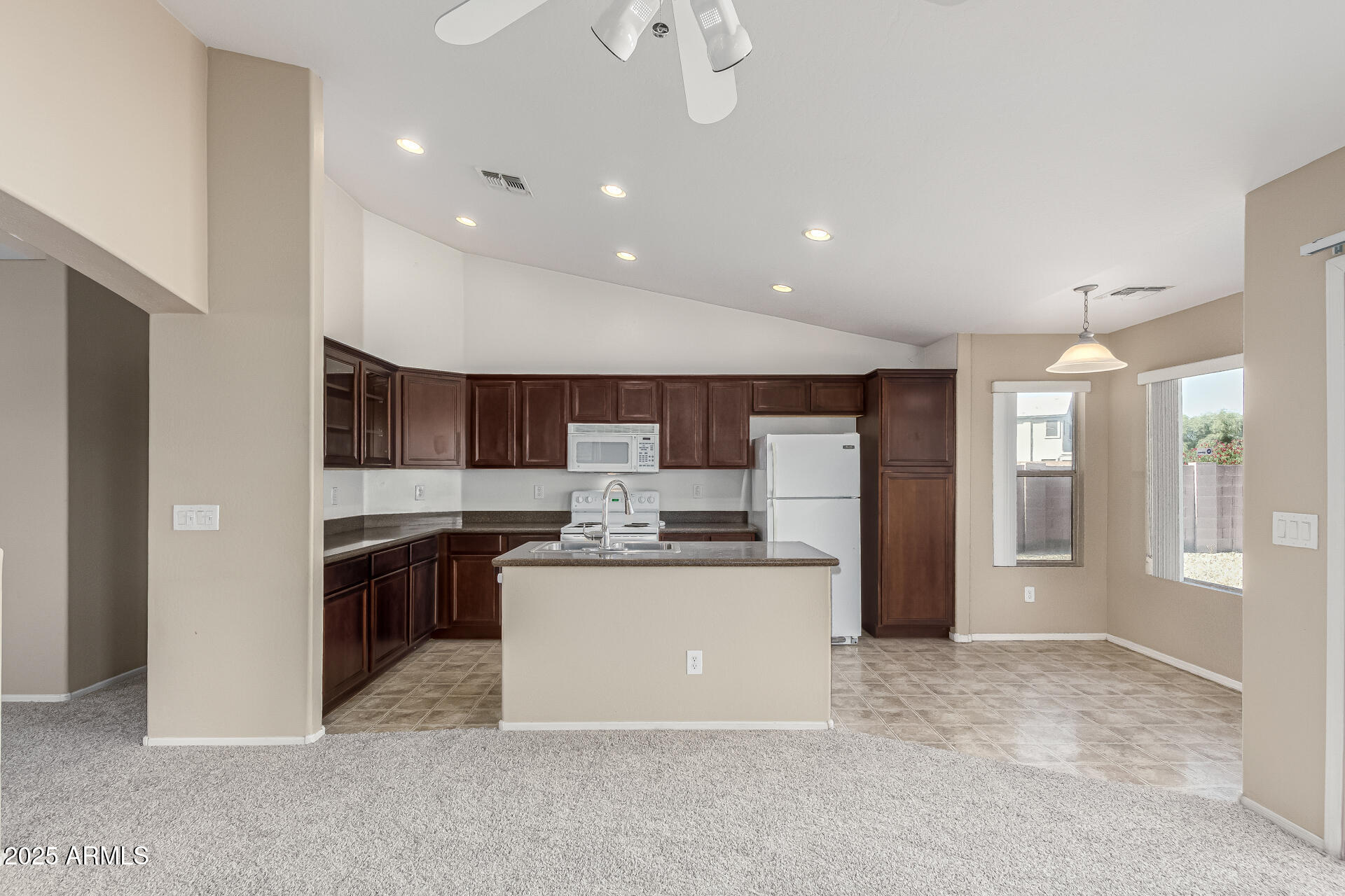 315 South 112th Drive Avondale, AZ 85323 - Photo 7 of 20 a kitchen with stainless steel appliances kitchen island granite countertop a refrigerator and a stove top oven