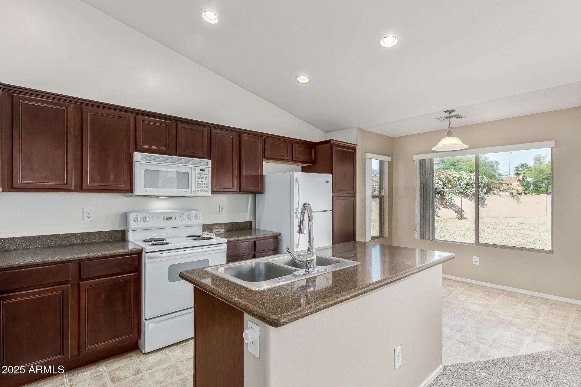 315 South 112th Drive Avondale, AZ 85323 - Photo 8 of 20 a kitchen with stainless steel appliances granite countertop a sink stove and refrigerator