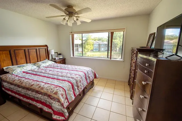 a bedroom with a bed and a flat tv screen on dresser