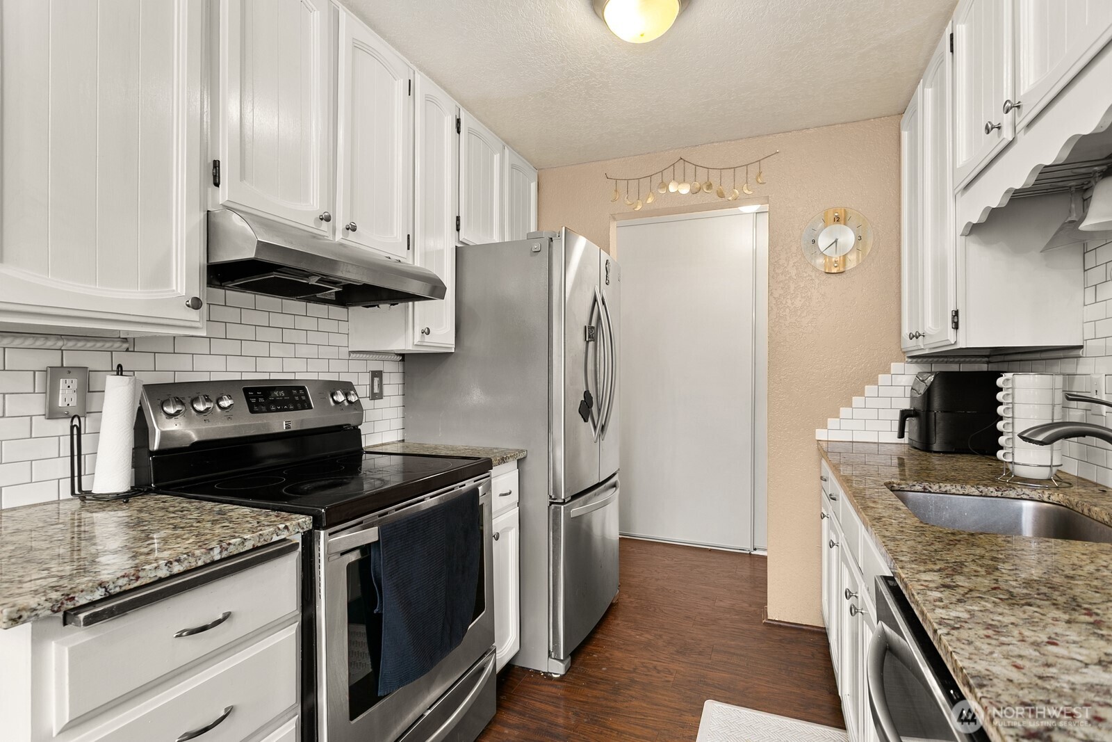 2031 Northwest 59th Street, Unit 101 Seattle, WA 98107 - Photo 13 of 22 a kitchen with stainless steel appliances granite countertop a stove a refrigerator and a granite counter tops