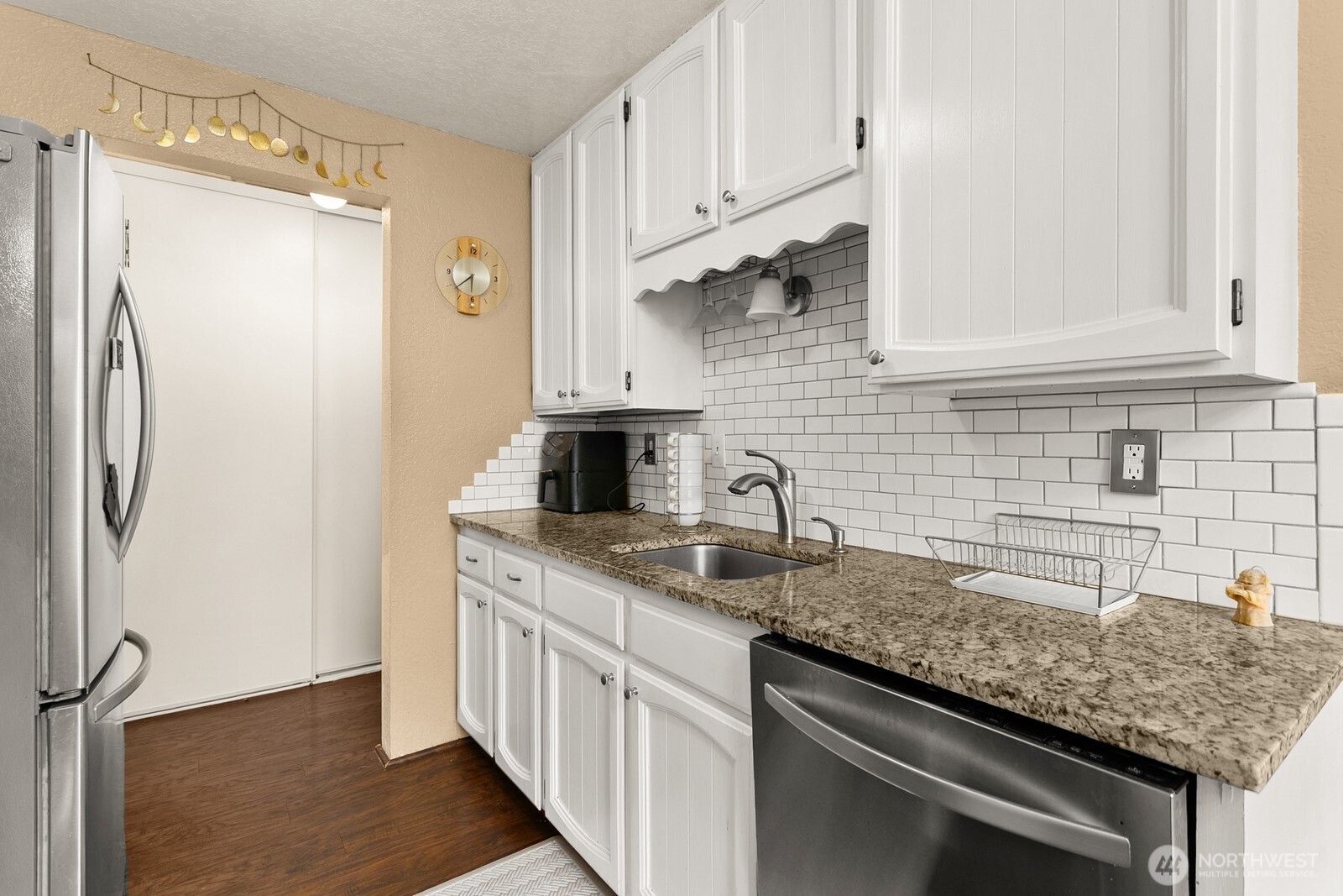 2031 Northwest 59th Street, Unit 101 Seattle, WA 98107 - Photo 14 of 22 a kitchen with stainless steel appliances granite countertop a sink stove and refrigerator