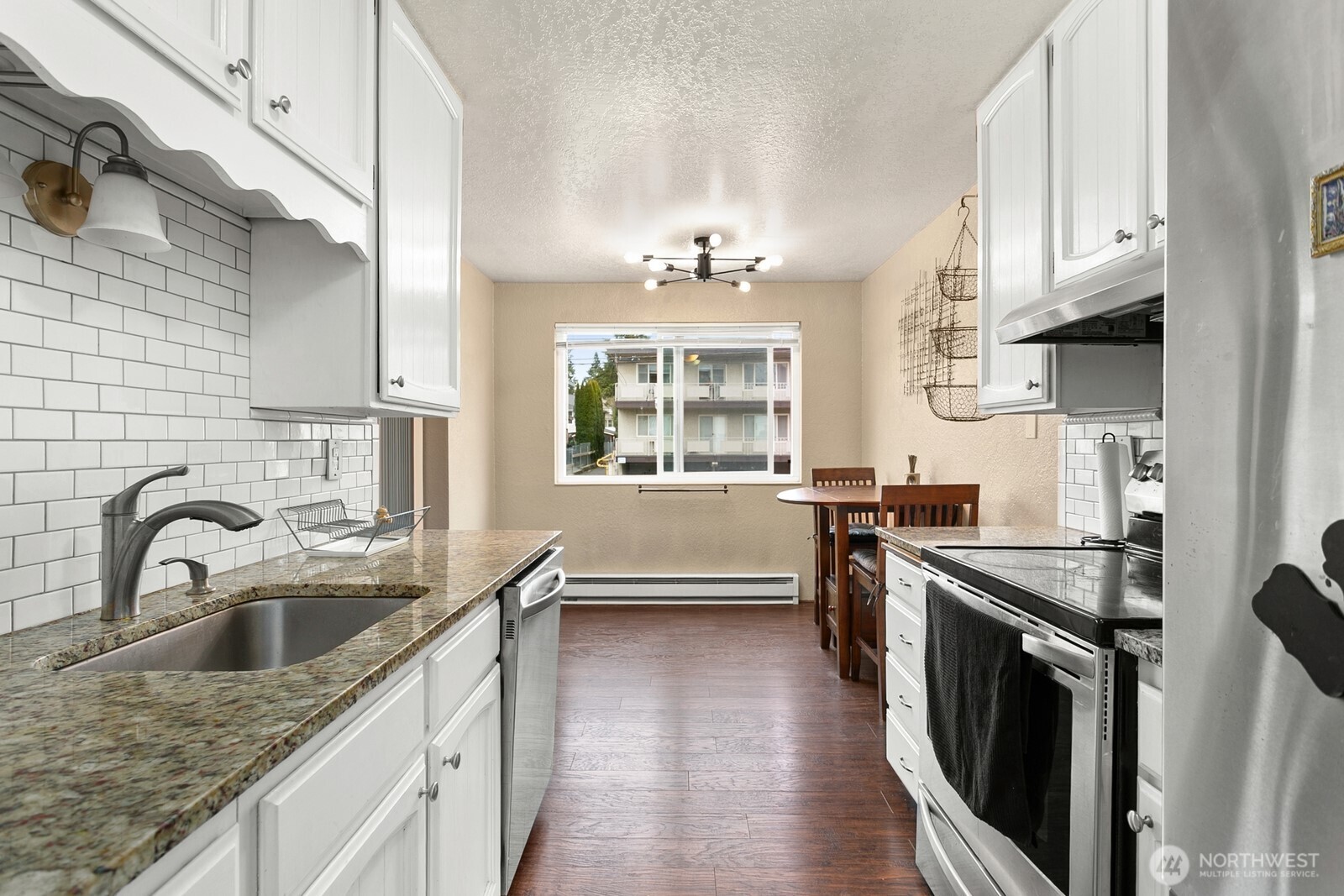 2031 Northwest 59th Street, Unit 101 Seattle, WA 98107 - Photo 15 of 22 a kitchen with granite countertop a sink a stove and cabinets