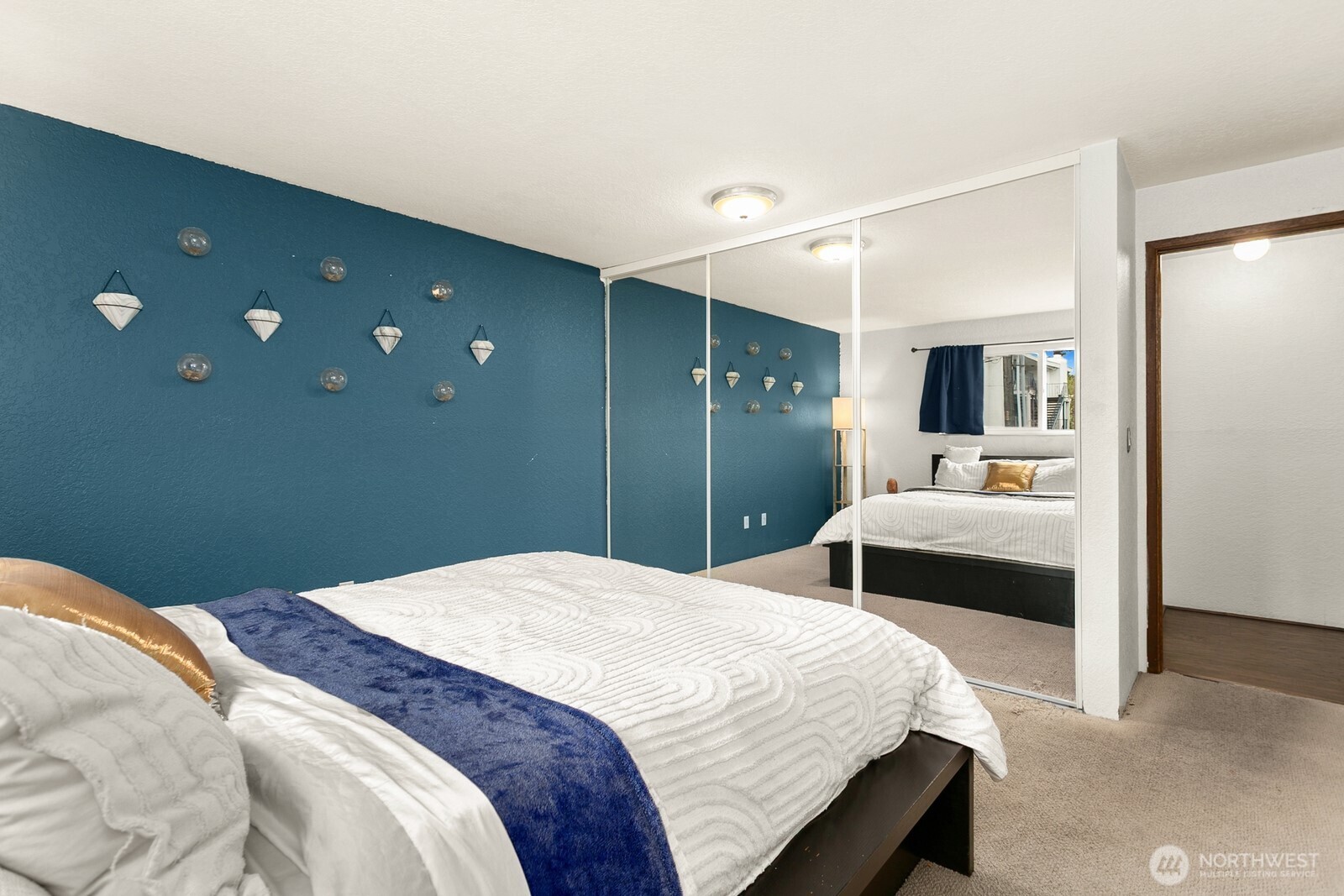 2031 Northwest 59th Street, Unit 101 Seattle, WA 98107 - Photo 17 of 22 a bedroom with a large bed and wooden floor
