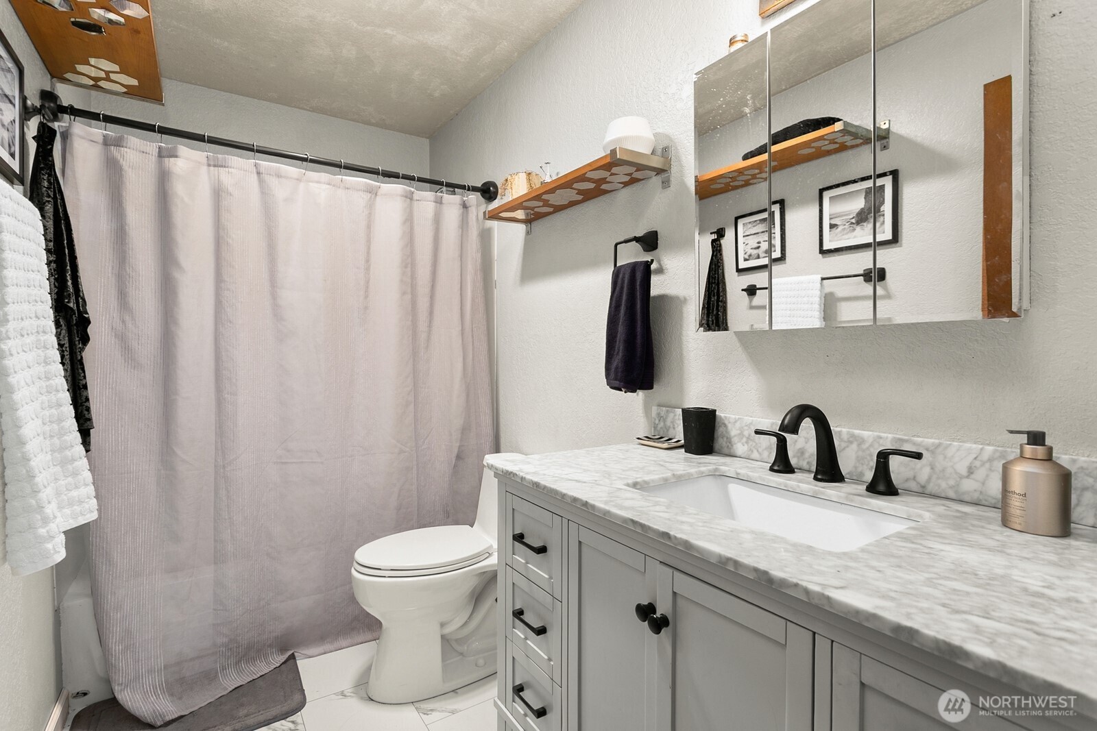 2031 Northwest 59th Street, Unit 101 Seattle, WA 98107 - Photo 19 of 22 a bathroom with a granite countertop sink a toilet and a mirror
